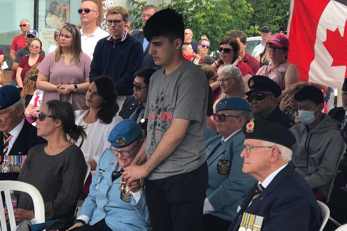 18-year-old Syrian refugee Rashid Sheikh Hassan, who recently came to Canada with the support of a sponsor group including Honorary Lieutenant Colonel Lee-Anne Quinn, holds her hand during the ribbon-cutting ceremony of The UN Peacekeepers Monument in Peterborough's new urban park on July 1, 2022. (Photo courtesy of Dave McNab)