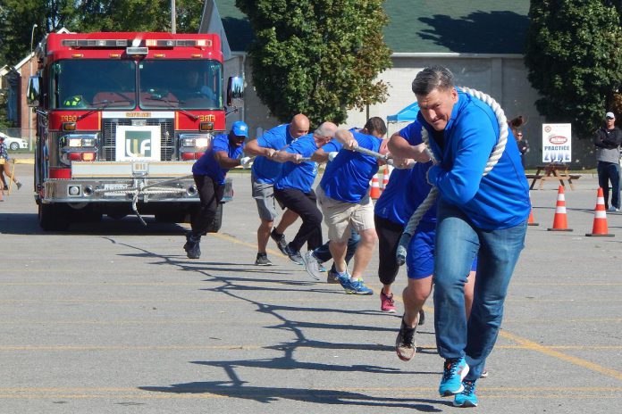 A determined Team RBC pulls a fire truck during a previous Pulling for Dementia Fire Truck Pull event. In this annual fundraiser for Alzheimer Society of Peterborough, Kawartha Lakes, Northumberland and Haliburton, teams of 10 to 12 people compete to pull a 44,000-pound fire truck the greatest distance in the least amount of time. The 2022 event takes place on Wednesday, September 21 at the Peterborough Airport. (Photo: Alzheimer Society of PKLNH)