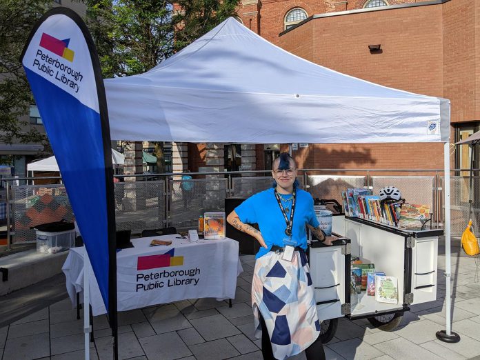 The Peterborough Public Library's "book bike" at the farmers' market. As well as encouraging literacy, environmental and otherwise, and supporting reuse by bring books to the community, the book bike is an environmentally friendly alternative to traditional gas-powered bookmobiles. (Photo courtesy of Peterborough Public Library)