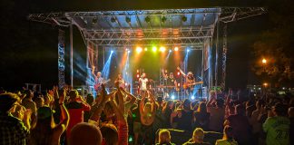 The Strumbellas (lead guitarist Jon Hembrey, violinist Isabel Ritchie, lead vocalist Jimmy Chauveau, drummer Jeremy Drury, keyboardist David Ritter, and bassist Darryl James) performed in Del Crary Park at Peterborough Musicfest on August 10, 2022. (Photo: Bruce Head / kawarthaNOW)