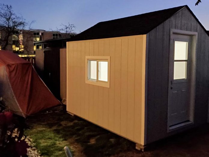In Kingston, a group called Our Livable Solutions created a sleeping cabin community at Portsmouth Olympic Harbour as a pilot project. The cabins in the Kingston project are fully insulated and wired with four 20-amp receptacles, an indoor light, an outdoor light, a heater, an air exchanger, and a tamper-proof smoke and CO2 detector. The community has shared bathrooms and showers, which the residents assist in keeping clean. (Photo courtesy of Our Livable Solutions)
