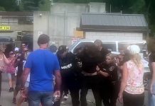 While other protesters watch, police arrest a man during an incident at the Peterborough police station on August 13, 2022. (kawarthaNOW screenshot of Twitter video)