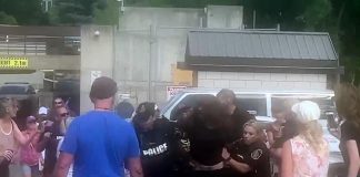 While other protesters watch, police arrest a man during an incident at the Peterborough police station on August 13, 2022. (kawarthaNOW screenshot of Twitter video)