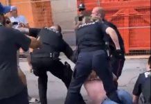A police officer pushes away a woman who attempted to interfere in an arrest during an incident at the Peterborough police station on August 13, 2022. It is unknown whether the woman is the one who was arrested and charged. (kawarthaNOW screenshot of Twitter video)
