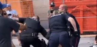 A police officer pushes away a woman who attempted to interfere in an arrest during an incident at the Peterborough police station on August 13, 2022. It is unknown whether the woman is the one who was arrested and charged. (kawarthaNOW screenshot of Twitter video)