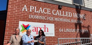 Glenn Wright (middle) and Margaret Cunningham and Jennifer Lopinski of the Community Foundation of Kawartha Lakes with a $7,500 for A Place Called Home at the non-profit organization's recently completed emergency shelter at 64 Lindsay Street South. (Photo courtesy of Community Foundation of Kawartha Lakes)