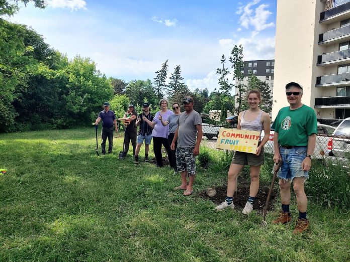 Volunteers strike a pose after planting apple trees next to the ever-growing edible fence line at Talwood Community Garden in Peterborough. A variety of edible plants have been sown along the line including apple, pear, elderberry, haskap, and rhubarb. (Photo: GreenUP)