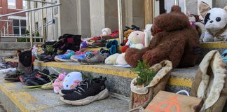 Children's shoes, toys, and offerings on the steps of Peterborough City Hall in June 2021, part of a community memorial created in response to the discovery of the remains of 215 Indigenous children buried at the former Kamloops Indian Residential School in British Columbia. As well as remembering and honouring those lost to residential schools and the thousands of survivors, National Day for Truth and Reconciliation is a day for Canadians to educate themselves about the heritage, culture, stories, and experiences of First Nations, Inuit, and Métis peoples. (Photo: Bruce Head / kawarthaNOW)