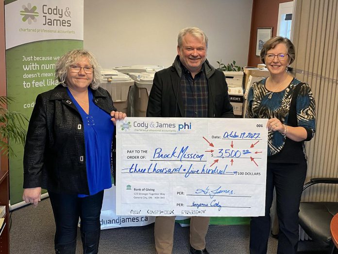 Suzanne Cody (left) and Gwyneth James (right), senior partners at Cody & James Chartered Professional Accountants in Peterborough, presented a $3,500 cheque to Brock Mission executive director Bill McNabb on October 20, 2022. (Photo courtesy of Cody & James CPA )