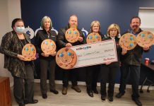 Alicia Vandine, donor relations and communications lead for Community Care Peterborough, with a cheque for $92,608.26 presented by local Tim Hortons owners Erika Howe-Gallagher, Ryan Graham, Donna Annett, and Mary and Greg Blair. (Photo courtesy of Community Care Peterborough)