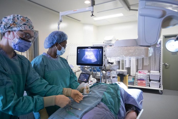 Interventional radiologist Dr. Kebby King (right) and registered technologist Saara King prepare for a minimally invasive interventional radiology procedure at Peterborough Regional Health Centre (PRHC). Often described as 'the future of medicine', it's used to diagnose and treat a wide range of emergency and chronic health conditions, such as cancer and other illnesses, without the use of conventional surgery.  (Photo courtesy of PRHC Foundation)