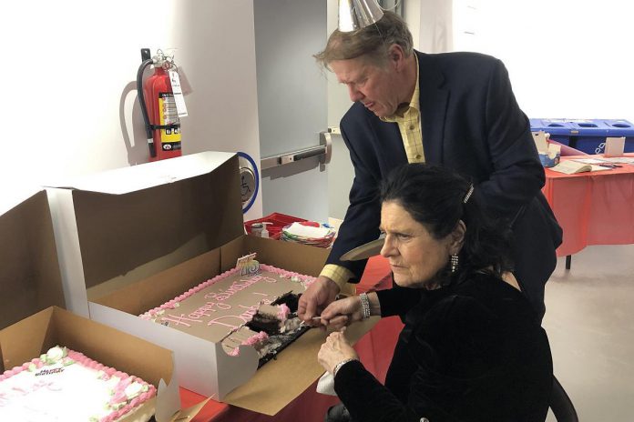 Public Energy executive director Bill Kimball helps Madame Daphne Jane Rogers Molson cut a cake during her 75th birthday celebration at the Peterborough Public Library on December 14, 2022. (Photo: Eva Fisher)