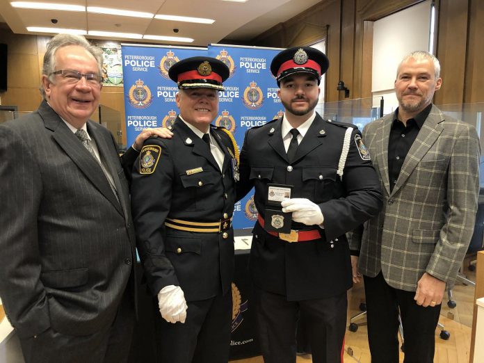Peterborough mayor Jeff Leal, Peterborough Police Service acting chief Tim Farquharson, and police services board member Drew Merrett with constable Dominic Moukarzel, one of the six new officers who were officially sworn in on December 19, 2022 at Peterborough City Hall. (Photo courtesy of Peterborough Police Service)