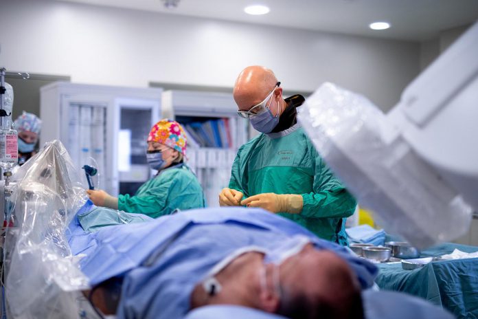 Dr. Warren Ball, interventional cardiologist and head of the cardiology division at Peterborough Regional Health Centre (PRHC), and members of the cardiac catheterization laboratory team provide a mock demonstration of the newly replaced and upgraded suites. Donors to the PRHC Foundation invested $3.55 million in the initiative to help "keep our hearts here" by ensuring life-saving cardiac care can remain available close to home. (Photo: Michael Hurcomb)