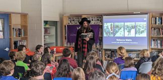 Hamilton-based musician, artist, and author Tom Wilson reads from his memoir "Beautiful Scars" during a December 8, 2022 event at Immaculate Conception Catholic Elementary School in Peterborough organized by the Gord Downie & Chanie Wenjack Fund in partnership with Sony Music Publishing. Wilson told the students about his discovery nine years ago, at the age of 54, that he was actually Indigenous. (Photo: Bruce Head / kawarthaNOW)