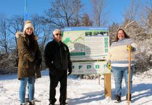 Eliza Braden-Taylor, Chief Keith Knott, and Anne Taylor of Curve Lake First Nation at a new Jackson Creek Trail trailhead sign during an event on January 14, 2023 to celebrate the the completion of Ontonabee Conservation's Jackson Creek Trail revitalization project. Curve Lake First Nation Cultural Centre helped develop the educational signs that were part of the project, which also included installing new trailhead signs and benches, fixing erosion along the trail, installing culverts, regrading slopes, enhancing bridges and railings, and resurfacing the length of the trail. (Photo courtesy of Otonabee Conservation)