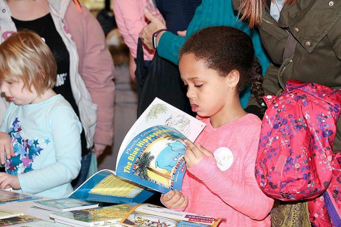A young reader explores a book during a previous Peterborough Family Literacy Day event at Peterborough Square. After a two-year absence because of the pandemic, the annual event returns for the morning of Saturday, January 28, 2023. (Photo courtesy of Peter Rellinger)