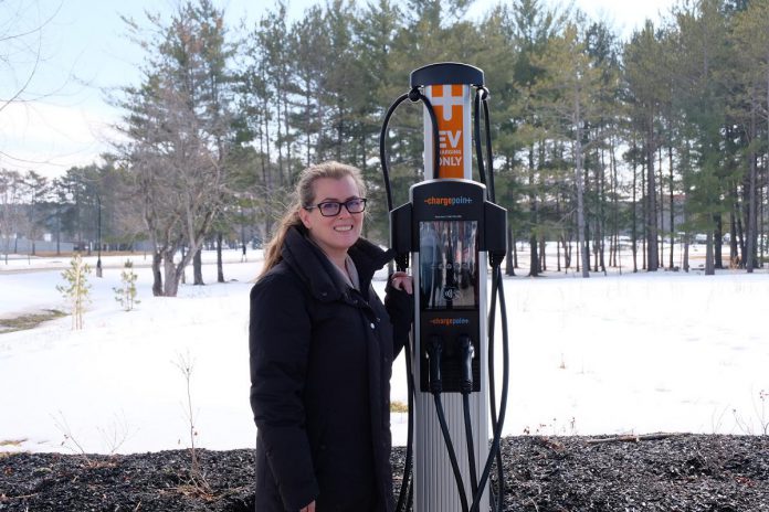 Trent University sustainability coordinator Shelley Strain at Level 2 charging station located by Lady Eaton College on the west bank of the university's campus. The hourly rate for charging there is $1.50, and a Trent parking permit is required as well. (Photo: Lili Paradi / GreenUP)