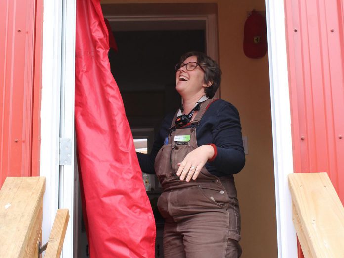 GreenUP Registered Energy Advisor Clara Blakelock sets up a blower door. The blower door test is used to assess the air leakage in a home. (Photo: Lili Paradi / GreenUP)