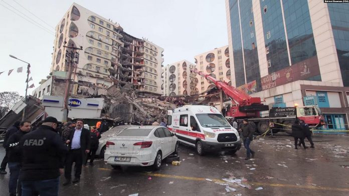 A search-and-rescue team at the destroyed Galeria Business Center in Diyarbakir in sotheastern Turkey, a city with a population of 1.8 million, on February 6, 2023 when a magnitude 7.8 earthquake struck southern Turkey and northern Syria. One of the buildings in the background later collapsed following an aftershock. (Photo: Mahmut Bozarslan / Voice of America)