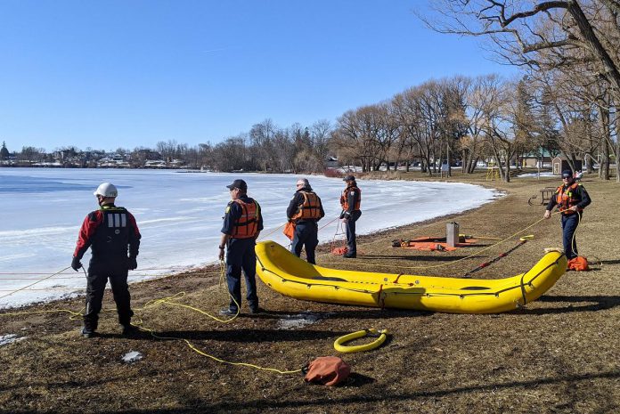 Peterborough Fire Services captain and chief training officer Dave Gillespie (left, in white helmet) supervising the annual operational training exercises in Peterborough's Little Lake on February 14, 2023. (Photo: Bruce Head / kawarthaNOW)