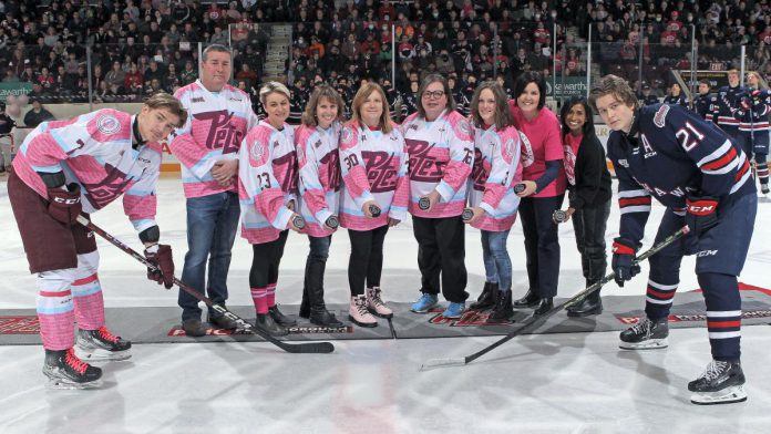 Five local hockey moms and Pink In The Rink campaign ambassadors (Jennie Ireland, Dara Gosselin, Elke Rye, Karen Tarkington, and Dana Thorn) joined PRHC Foundation president and CEO Leslie Heighway and PRHC oncologist Dr. Neera Jeyabalan for a ceremony before the 14th annual cancer fundraising game on February 4, 2023. (Photo: Kenneth Anderson Photography