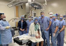 Patient Arthur Goard (seated) beside orthopaedic surgeon Dr. Sebastian Heaven at Ross Memorial Hospital in Lindsay on February 15, 2023 prior to the first Insignia femoral stem implant being used in hip arthroplasty surgery in Ontario. Also pictured from left to right: RPN Christine Ham, Registered Nurse First Assist Susan Dallas-Wood, RN Katie Oliver, anesthesiologist Dr. Mohammed Hussein, RN Michelle McCombe, and RN Kara Harman. (Photo courtesy of Ross Memorial Hospital)