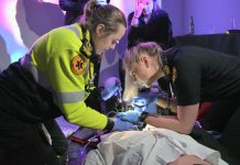 Paramedic students at Fleming College's on-campus simulation lab in 2019 participating in a simulation where a "groom" at a wedding (actually a high-fidelity manikin) was experiencing an anaphylactic response while surrounded by rowdy bystanders (played by graduates of the paramedic program). The students had to assess the groom and the scene to determine the appropriate treatment protocol. These scenarios help students prepare for real-world situations where they must act quickly under pressure. (Photo: Fleming College)