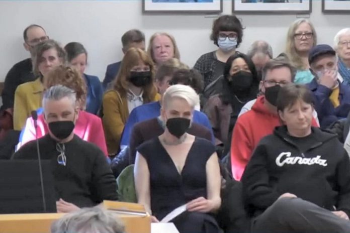 The Theatre On King's Ryan Kerr and Kate Story (front left and right) wait to appear before Peterborough City Council on March 27, 2023 to appeal the decision to deny the arts organization a community investment grant for 2023 after providing them the maximum grant in 2022. (kawarthaNOW screenshot of City of Peterborough video)