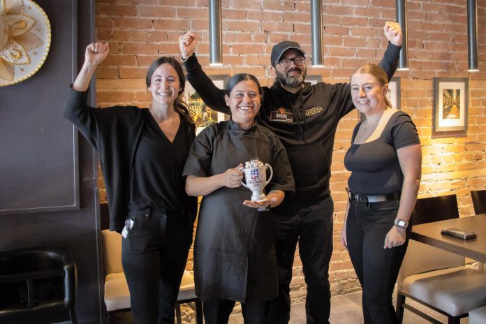 Chef Jennifer Guiterrez of Agave by Imperial holds the Top Hot Chocolatier trophy the Mexican restaurant in downtown Peterborough received as the champions of the inaugural Ptbo Hot Chocolate Fest. Also pictured from left to right are restaurant server Cynthia Routledge, restaurant owner and operator Nitin Grover, and sever Madison Imrie. (Photo courtesy of Peterborough DBIA)