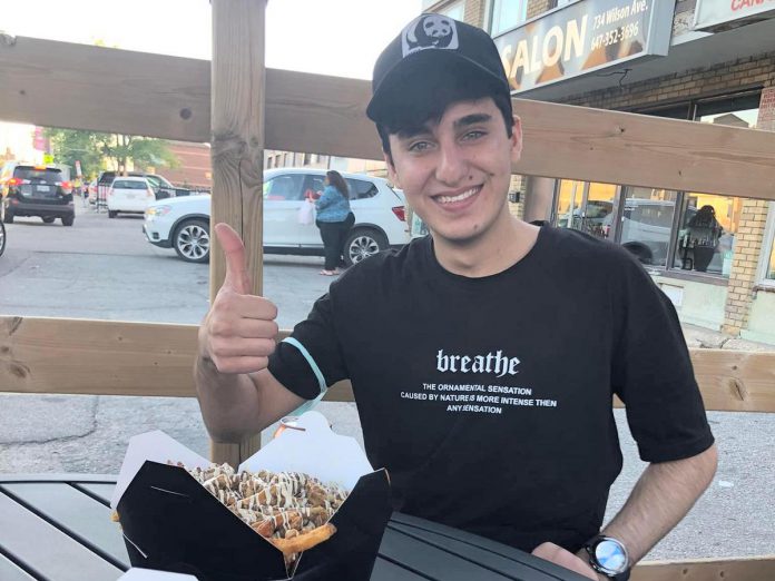 Shortly after leaving Pearson International Airport with his sponsors, Rashid tried poutine for the very first time on a restaurant patio. He and his sponsors sang O Canada in honour of Rashid’s arrival in his new home. (Photo courtesy of Dave McNab)