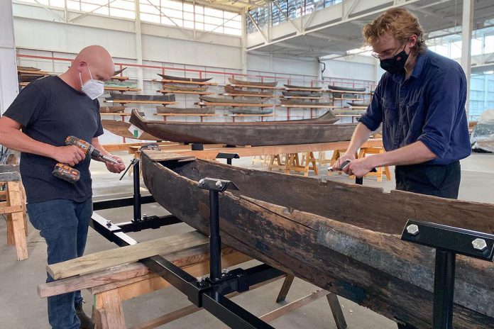 The Canadian Canoe Museum's curator Jeremy Ward (left) and collections assistant Nicholas VanExan build a steel cradle for one of the more than 600 watercraft that will be moved from the museum's Monaghan Road location to the museum's new home currently under construction at the water's edge on Little Lake in the heart of Peterborough. (Photo courtesy of The Canadian Canoe Museum)