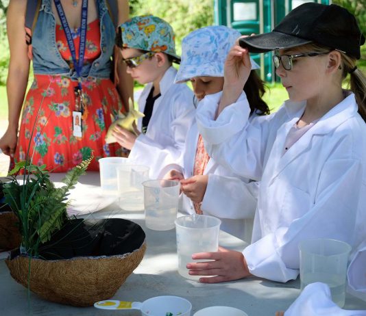 Young students during the first day of the annual Peterborough Children's Water Festival on May 30, 2023 donned lab coats and investigated various tests on liquids to understand the concept of acidity in water. (Photo: Lili Paradi / GreenUP)