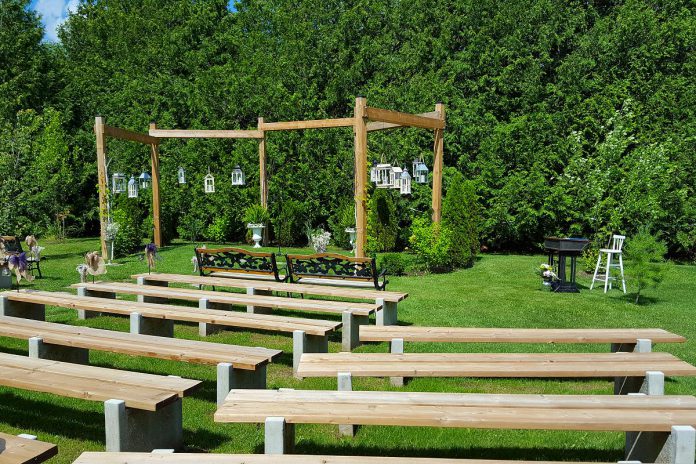 The outdoor ceremony area at Northview Gardens features a natural wood archway decorated with unique hanging lanterns, ivy, and white flowers, or couples can choose their own décor. (Photo courtesy of Northview Gardens)