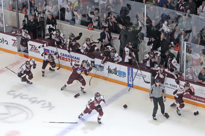 Players jump off the bench in front of a cheering sold-out hometown crowd at the Memorial Centre on May 21, 2023 after the Peterborough Petes defeated the London Knights 2-1 to win the OHL championship and the J. Roberston Cup in six games. (Photo courtesy of the Peterborough Petes)