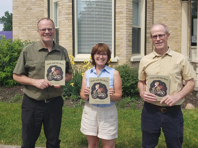 Peterborough author Erica Richmond (middle) with Peterborough Youth Services child and youth mental health program director Matt Sheridan (left) and executive director Gordon Langill with copies of Richmond's children's book "Pixie and the Bees". Richmond raised $670 for the organization by donating half of the proceeds of sales of the book during May 2023. (Photo courtesy of Erica Richmond)