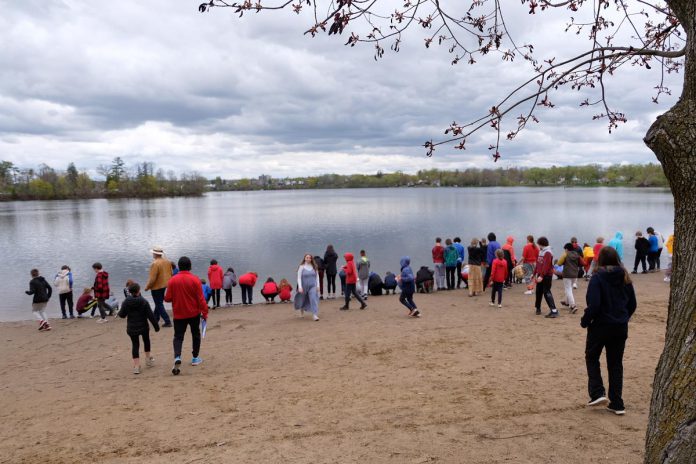 Students, staff, and participants stop at Beavermead beach to gift the sacred semaa (untreated tobacco) to Little Lake on May 5, 2023. Semaa is meant to absorb your prayers and thoughts, carrying them where they end up. (Photo: Lili Paradi, Sacred Water Circle / GreenUP)