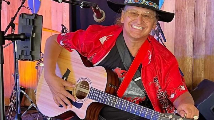 As part of the Nogojiwanong Indigenous Fringe Festival's family day on June 24, 2023, "Tiger" Will Mason will be performing songs and sharing stories for the whole family. Mason has performed on stages for over half of his life, including as an actor and a professional musician. In 1986, an Anishinabe elder gave him the spirit name "Kahntahwi-wim'tchi'get", which means "Maker of Beautiful Music". He combines native contemporary sounds, with bluegrass, Americana, Canadiana, country rock, blues rock, folk, and more. (Photo: Tiger Will Mason / Facebook)