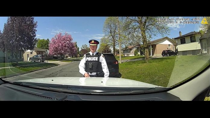 Peterborough police chief Stuart Betts demonstrates the in-car camera system that has been installed in 25 police vehicles, including all marked cruisers and some unmarked crusiers. The system will record audio and video for front-facing activity outside the vehicle and within the prisoner-control area of the rear seat, with the forward-facing cameras connected to a microphone an officer wears that captures all audio communication when the in-car camera system is active. (kawarthaNOW screenshot)