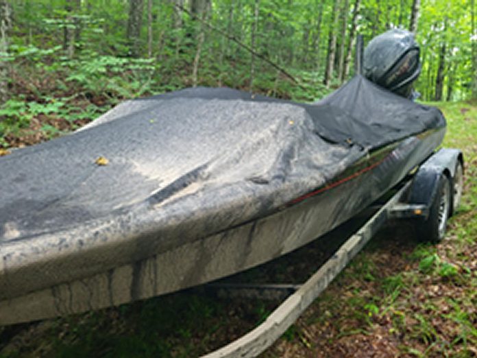 While searching a Trent Lakes address on June 26, 2023 for a stolen dock worth $47,000, police also recovered a boat, motor, and trailer valued at around $150,000.  A 46-year-old Trent Lakes man has been arrested and charged with multiple counts of possession of stolen property and theft. (Photo: Peterborough County OPP)