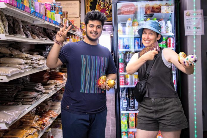 Susan Donald (right), pictured with Bhojan Indian grocery store co-owner Aniket Khera, won $1,500 in Boro gift cards after participating in the Peterborough Downtown Business Improvement Area's 'golden goose chase' spring downtown shopping promotion. (Photo courtesy of Peterborough DBIA)