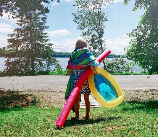 A young girl with gear during summer heading to a beach for a swim. (Stock photo)