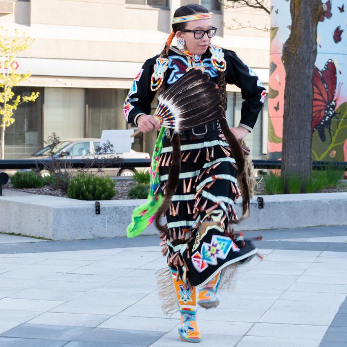 Kelli Marshall performing a jingle dress dance in the courtyard of Peterborough Square in May 2023 during the "Hot Spots" series of performances hosted by Artsweek Peterborough. (Photo: Andy Carroll for Electric City Culture Council)