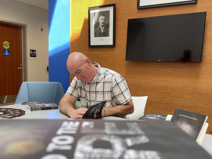 Peterborough author Matthew Flagler with copies of his new book "Held to the Fire," which he calls an authentic retelling of the most tragic event in the city's history: the 1916 explosion and fire that destroyed the Quaker Oats plant on Hunter Street and claimed the lives of 24 workers. (Photo courtesy of Matthew Flagler)