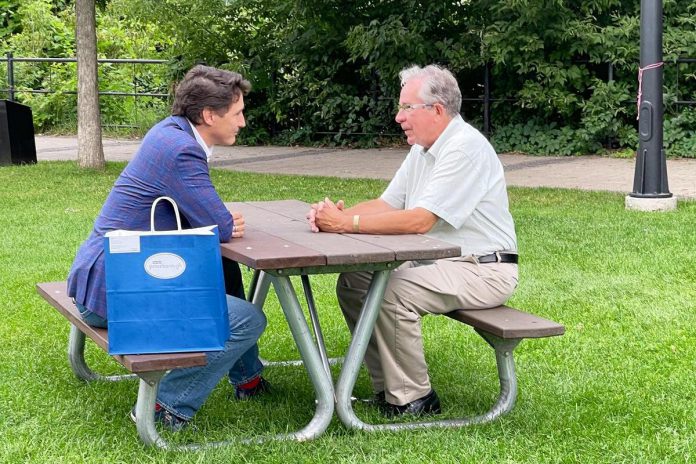 Prime Minister Justin Trudeau sits with Mayor Jeff Leal at a picnic table in Millennium Park during a visit to Peterborough on July 20, 2023. (Photo: City of Peterborough / Twitter)