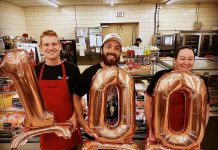 In June 2023, Flame Spitter Hot Sauce owner Mitchell Lowes (middle) celebrated his 100th retail location at Buckhorn Foodland. He originally started the business in 2021 with a partner, but now runs it on his own. He credits the fast growth of his company both to his sobriety and the support of the community, including from Community Futures Peterborough. (Photo courtesy of Flame Spitter Hot Sauce)