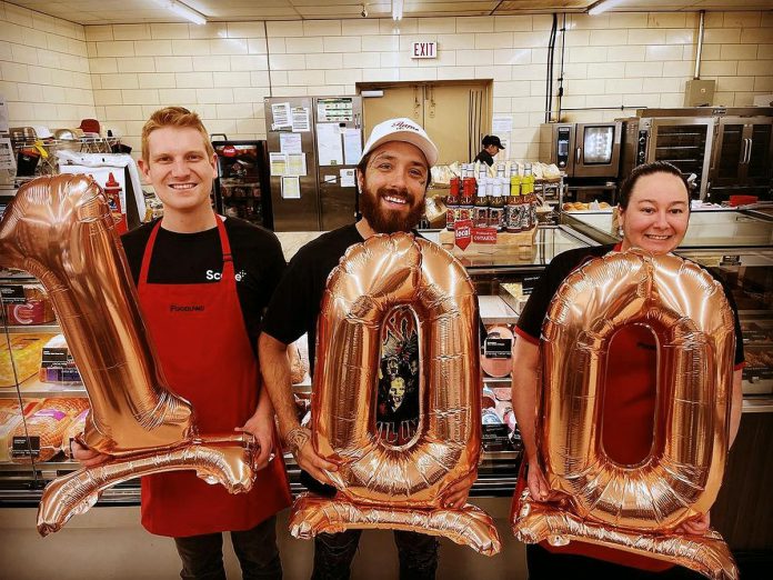 In June 2023, Flame Spitter Hot Sauce owner Mitchell Lowes (middle) celebrated his 100th retail location at Buckhorn Foodland. He originally started the business in 2021 with a partner, but now runs it on his own. He credits the fast growth of his company both to his sobriety and the support of the community, including from Community Futures Peterborough. (Photo courtesy of Flame Spitter Hot Sauce)