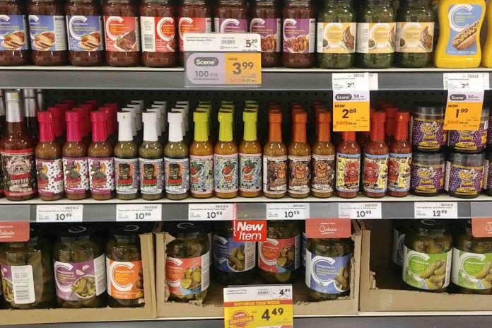 Flame Spitter Hot Sauce products line a shelf among other condiments at a Foodland grocery store.  (Photo courtesy of Flame Spitter Hot Sauce)