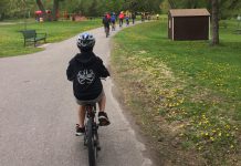 A student-led bike club rides through Rogers Cove park in Peterborough's East City. Active school travel helps school-aged children meet the recommendation to accumulate at least 60 minutes per day of moderate to vigorous physical activity, which is associated with improved physical and mental health. (Photo: GreenUP)