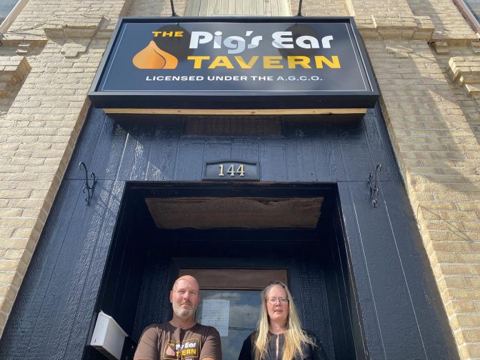 The Pig's Ear Tavern owners Steve Robertson and Ashley Holmes at the pub's entrance at 144 Brock Street in downtown Peterborough. The former Trent University students purchased the building in 2022 with help from two investors, and are hard at work to restore the beloved pub to its former glory and introduce some of the events that made it a unique destination for the community, with an expected opening in fall 2023. (Photo: Paul Rellinger / kawarthaNOW)
